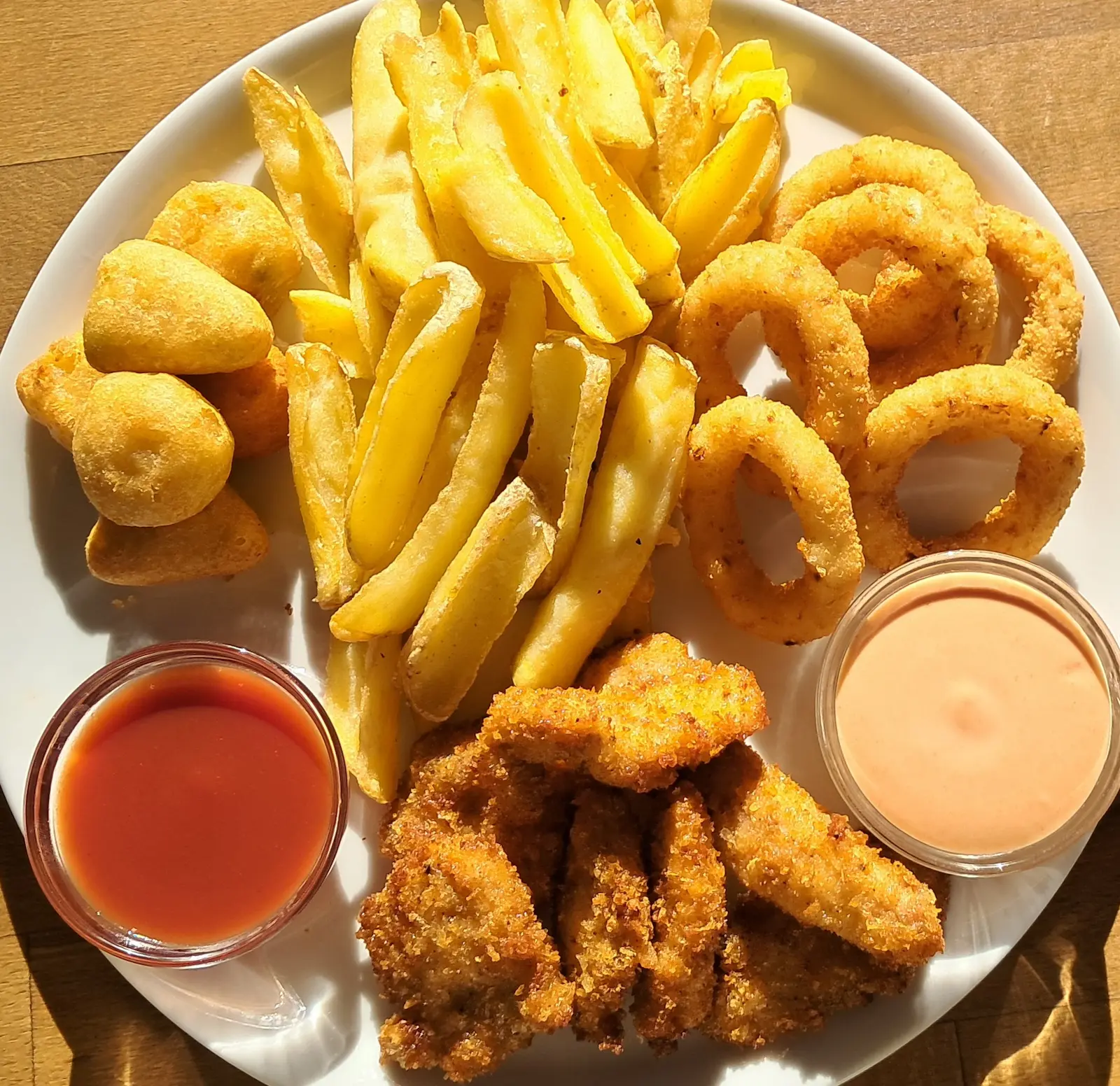 Beer platter with chicken nuggets, fries, cheese bites, onion rings and dips