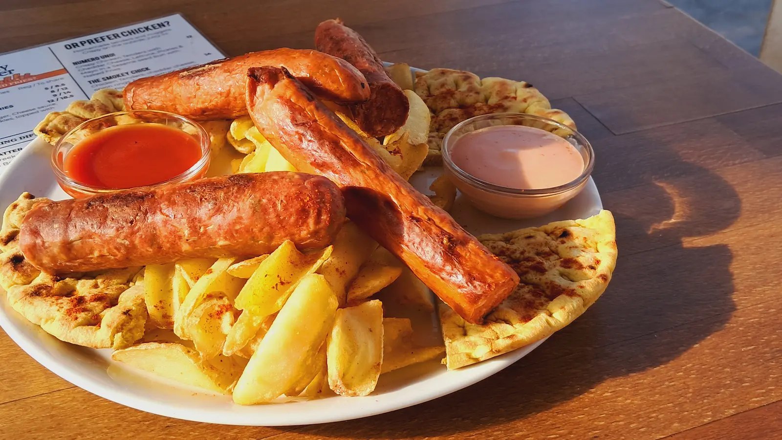 Sausage platter with Greek sausages, fries, dips and pita